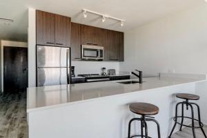 a kitchen with a counter and two bar stools at Downtown 1br w gym wd near restaurants ATX-230 in Austin