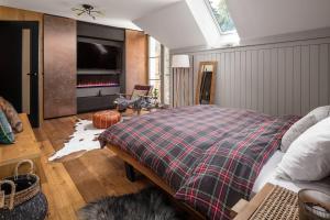 a bedroom with a bed with a plaid blanket at Peaceful, Cozy Designer Mountain Studio in Harrachov