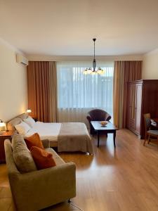 a hotel room with a bed and a couch at Arcada Apartments in Odesa