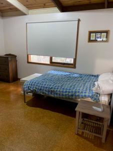 a bedroom with a bed with a window and a table at Lyall Street Beach Cabin in Ventnor