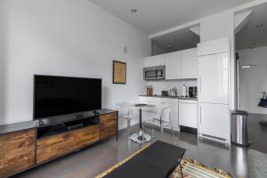 a living room with a flat screen tv and a kitchen at Downtown studio w gym laundry nr shopping BOS-987 in Boston