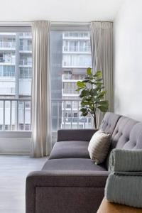 een woonkamer met een bank en een groot raam bij Media Luna Studio Oceanview Pool in San Juan