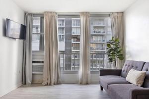 een woonkamer met een bank en een groot raam bij Media Luna Studio Oceanview Pool in San Juan