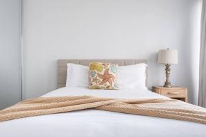 een bed met een deken erop bij Media Luna Studio Oceanview Pool in San Juan