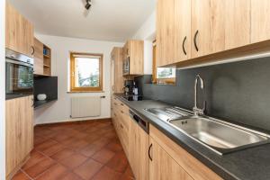 a kitchen with wooden cabinets and a sink at Bergchalet "Haus Sonja" in Katschberghöhe +11 photos