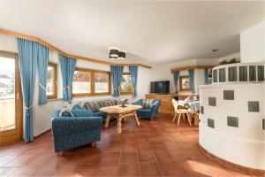 Bergchalet "Haus Sonja" في كاتشبيرغوهي: غرفة معيشة مع كراسي زرقاء وطاولة