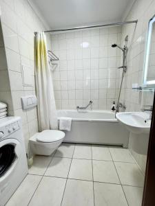 a bathroom with a tub and a toilet and a sink at Arcada Apartments in Odesa +34 photos