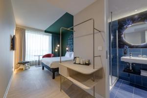 una habitación de hotel con una cama y un baño en ibis Styles Rotterdam Ahoy, en Róterdam 111 fotos más