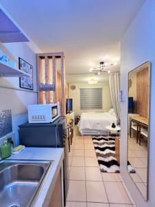 a kitchen with a sink and a bedroom with a bed at Studio Unit-8 Spatial Condo in Davao City