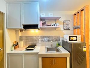a kitchen with a sink and a refrigerator at Studio Unit-8 Spatial Condo in Davao City +2 photos