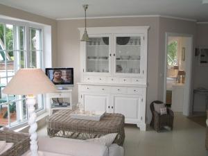 ein Wohnzimmer mit einem weißen Schrank und einem TV in der Unterkunft Godeke Michels Ferienwohnung 35Susewind Müggenburger Weg 40 in Zingst