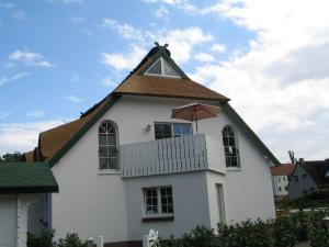 ein weißes Haus mit einem Dach mit einem Regenschirm drauf in der Unterkunft Godeke Michels Ferienwohnung 35Susewind Müggenburger Weg 40 in Zingst