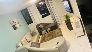 uma sala de estar com um sofá e uma cadeira em Windhoek City Center self catering appartment em Windhoek