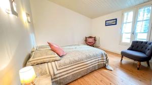 um quarto com uma cama e uma cadeira azul em Charmante villa à étage à Sainte-Marie avec cour em Sainte-Marie-de-Ré
