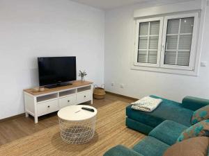 a living room with a couch and a flat screen tv at Grupo Gontad Casa Secundino in Asalo