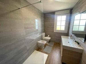 a bathroom with a sink and a toilet and a tub at Grupo Gontad Casa Secundino in Asalo +20 photos