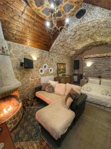 a living room with a couch in a stone wall at Anilia Guesthouse in Synikia Mesi Trikalon