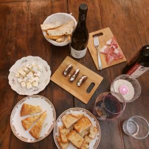 una mesa con platos de comida y una botella de vino en Agriturismo Tenuta La Fratta, en Bagni di Lucca