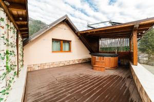 uma casa com uma banheira de hidromassagem num deque em Carpe Diem em Bran