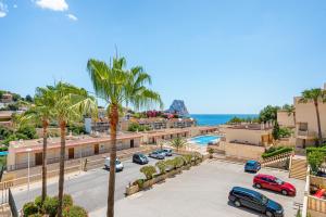 een uitzicht op een parkeerplaats met palmbomen en de oceaan bij Apartment Manzanera 5 - PlusHolidays in Calpe