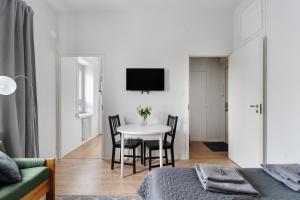 uma sala de estar com uma mesa e cadeiras e uma televisão em Nordic Studio near tram & metro 'Kallio' area em Helsinque