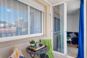 een woonkamer met een tafel en een groot raam bij Apartment Manzanera 5 - PlusHolidays in Calpe