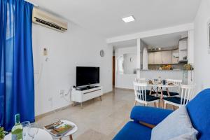 een woonkamer met een blauwe bank en een keuken bij Apartment Manzanera 5 - PlusHolidays in Calpe