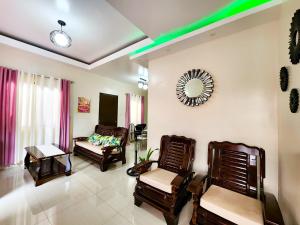 a living room with chairs and a couch and a mirror at Serene 2BR Escape: Poolside Bliss in Iloilo City in Iloilo City