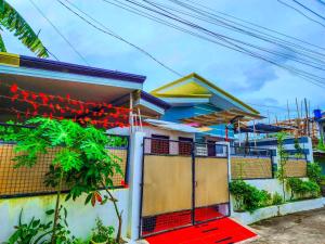 a house with a red gate in front of it at Serene 2BR Escape: Poolside Bliss in Iloilo City in Iloilo City