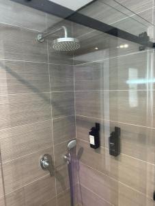 een badkamer met een douche en een glazen wand bij Appartement La Croisette in Nabeul