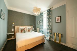 um quarto com uma cama grande e uma janela em Hôtel Des Batignolles em Paris
