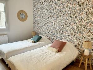 two beds in a room with a wall at Le Julia - Neuf - Gare et garage in Compiègne