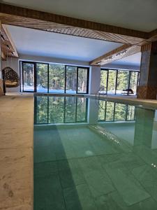 een kamer met een zwembad met glazen vloeren en ramen bij "Park Hotel Ela" in Borovets