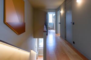 Cette chambre dispose d'un couloir et de parquet. dans l'établissement Gilreu Beach Duplex Apartments in Foz by LuxiStay, à Porto