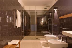 a bathroom with two toilets and a glass shower at Gilreu Beach Duplex Apartments in Foz by LuxiStay in Porto