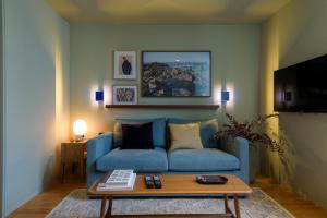 Gilreu Beach Duplex Apartments in Foz by LuxiStay في بورتو: غرفة معيشة مع أريكة زرقاء وطاولة قهوة