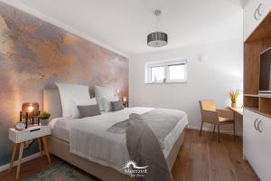 Un dormitorio con una gran cama blanca y una pared en Ebbe und Flut- direkt am Wasser, Hafenblick, Fahrstuhl, Sauna, ueberdachte Terrasse en Olpenitz