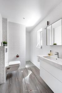 a white bathroom with a sink and a mirror at Ebbe und Flut- direkt am Wasser, Hafenblick, Fahrstuhl, Sauna, ueberdachte Terrasse in Olpenitz
