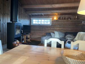 ein Wohnzimmer mit einem Sofa und einem Tisch in der Unterkunft Maurtua - cabin in lovely surroundings in Mysusæter