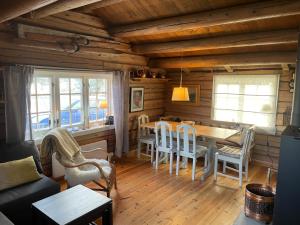 uma sala de estar com uma mesa e cadeiras num camarote em Maurtua - cabin in lovely surroundings em Mysusæter