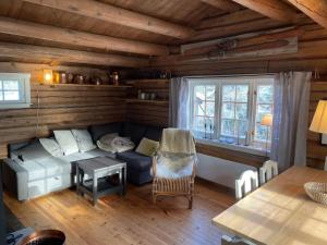 a living room with a couch and a table at Maurtua - cabin in lovely surroundings in Mysusæter