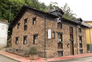 ein großes Backsteingebäude mit Fenstern auf einer Straße in der Unterkunft Apartamentos Turisticos A Estacion in A Pontenova