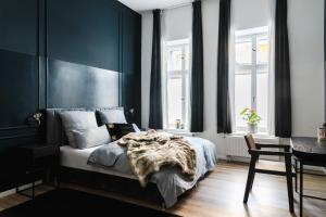 a bedroom with black walls and a bed with a blanket at Exklusive Luxus-Unterkunft in Berlin Mitte: 2 Apartments, 130m², Designer-Möbel, Co2 neutrale Reinigung in Berlin