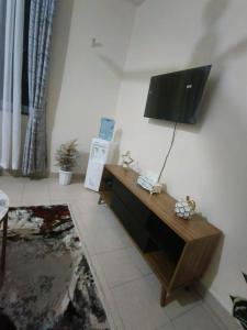 sala de estar con TV de pantalla plana en la pared en Joly Apartments, Nyali Mombasa, en Mombasa