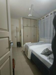 a bedroom with a large bed and a window at Joly Apartments, Nyali Mombasa in Mombasa