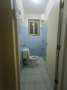 a bathroom with a toilet and a window at Joly Apartments, Nyali Mombasa in Mombasa