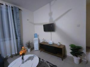 a living room with a flat screen tv on the wall at Joly Apartments, Nyali Mombasa in Mombasa