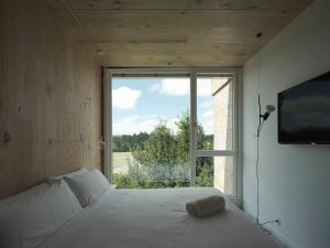 a bedroom with a bed and a large window at Hotel Amiuka in O Pedrouzo