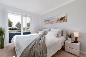 Habitación blanca con cama y ventana en Ferienwohnung Schleiperle, en Olpenitz