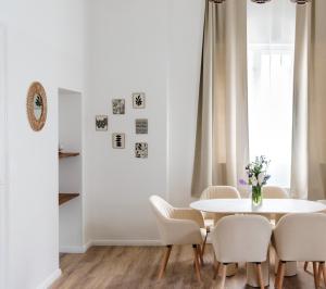 a white dining room with a white table and chairs at Exklusive Luxus-Unterkunft in Berlin Mitte: 2 Apartments, 130m², Designer-Möbel, Co2 neutrale Reinigung in Berlin